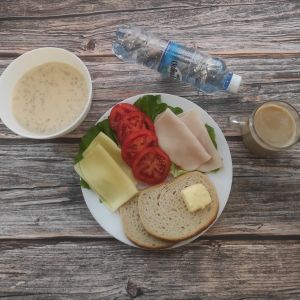 Zdjęcie przedstawia Dietę podstawową: Kawa zbożowa z mlekiem Owsianka z jabłkami Chleb mieszany pszenno-żytni Masło extra Szynka tostowa- drobiowa Ser ż&oacute;łty Pomidor Woda źr&oacute;dlana Sałata zielona